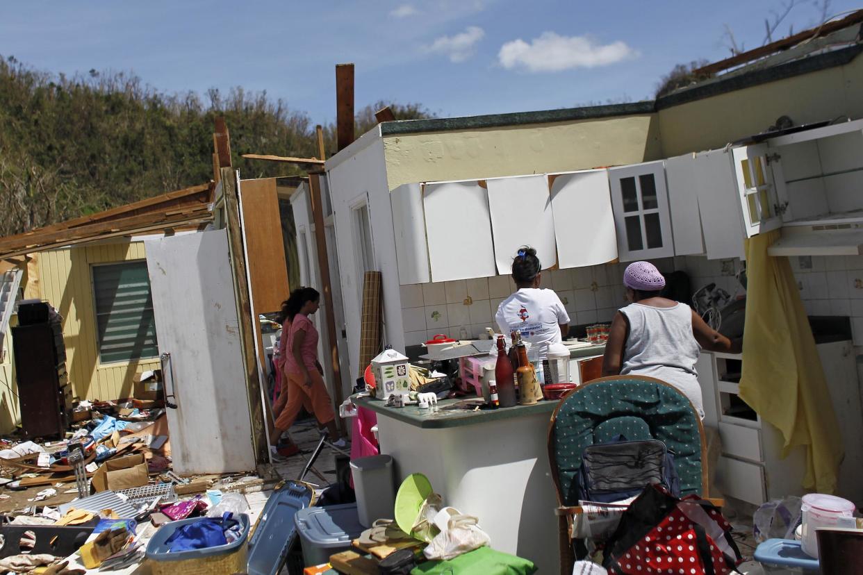 Family members collect belongings after hurricane-force winds destroyed their house in Toa Baja, west of San Juan, Puerto Rico: AFP/Getty