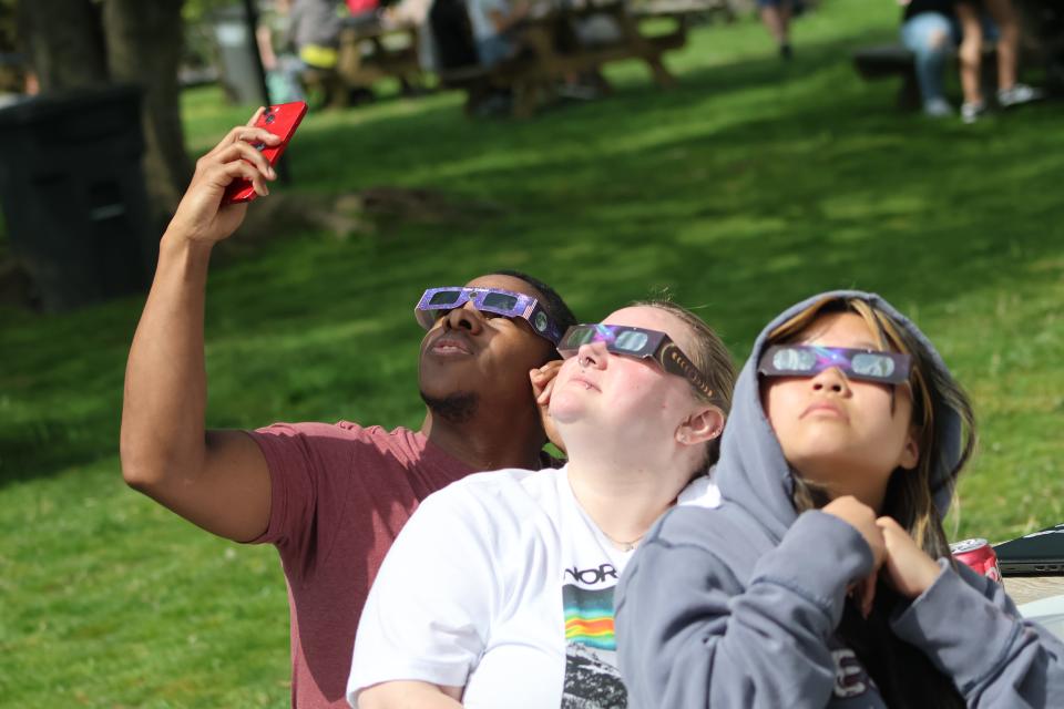 Casey and Mikaylyn Burns and Aislynn Donahoe capture images of Monday's eclipse on April 8, 2024 in Clarksville, Tenn.