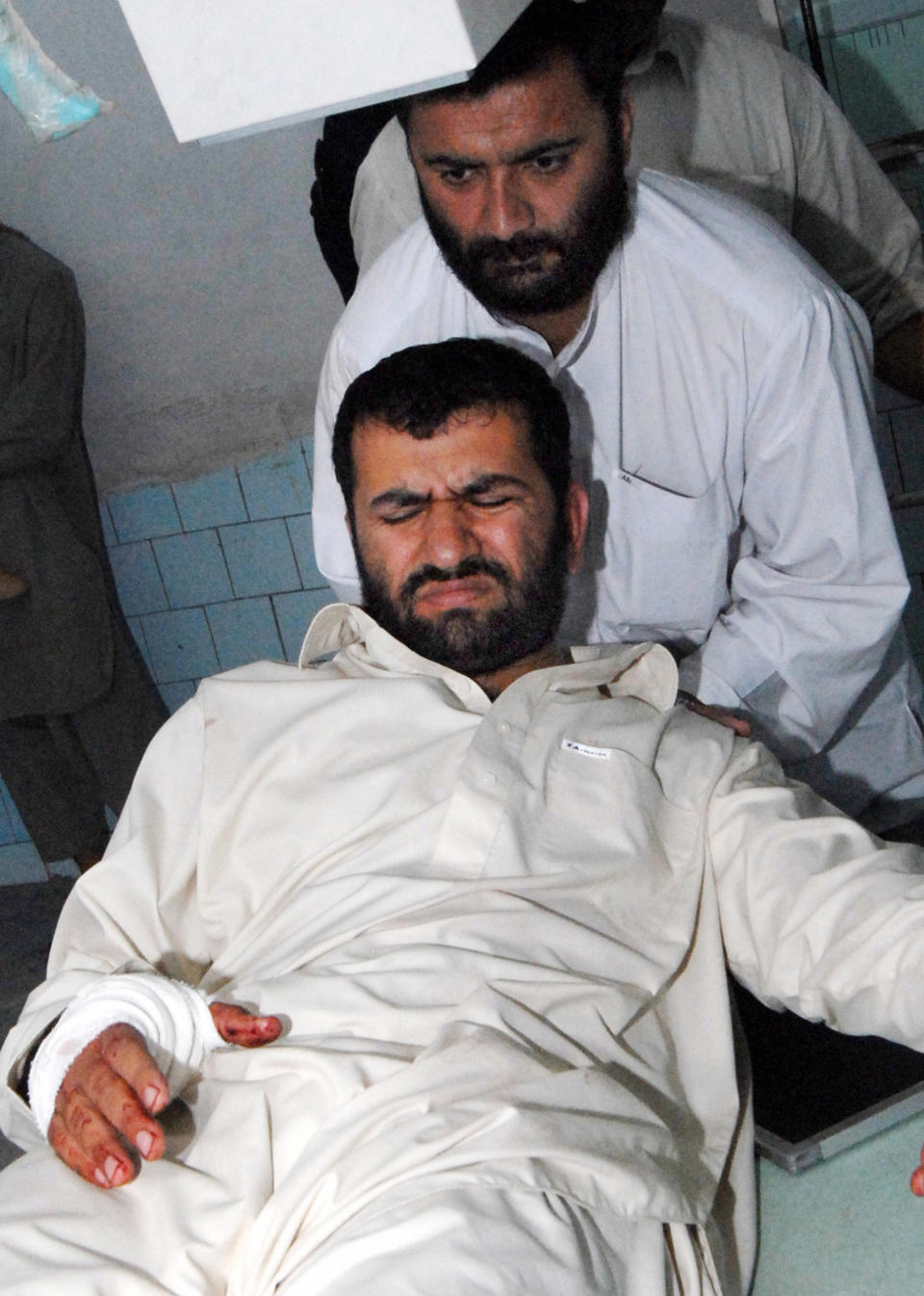 A relative helps injured Afghan journalist Sami Yousafzai at a hospital in Peshawar, November 14, 2008, after he and a Japanese journalist were shot and injured by Taliban militants. / Credit: TARIQ MAHMOOD/AFP/Getty