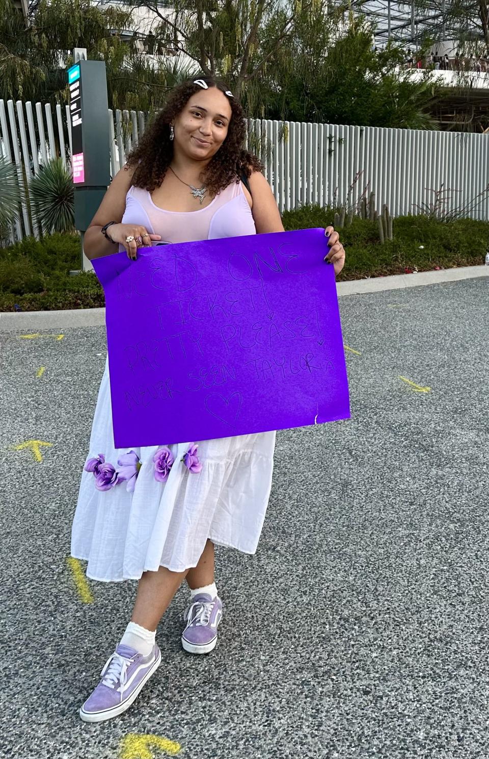 Dior Jazmine stands outside SoFi Stadium in Los Angelas, Calif. on Wednesday, Aug. 11, 2023 holding a sign looking for tickets to get inside a Taylor Swift concert. | Sarah Gambles, Deseret News