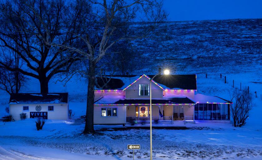 DENISON, IOWA - JANUARY 17, 2024: A photograph of Donald Trump's face hangs in the living room window over the front porch while an election banner for Vivek Ramaswamy hangs on the garage of a rural home on January 17, 2024 in Denison, Iowa. The residents choice for Republicans is indicative of the voters in Denison, including the Latino vote. The town is 50% Latino.(Gina Ferazzi / Los Angeles Times)