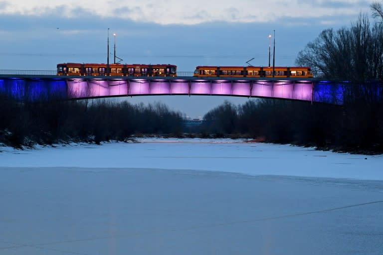 Tramways cross a bridge over the partially frozen Vistula river in the Polish capital Warsaw