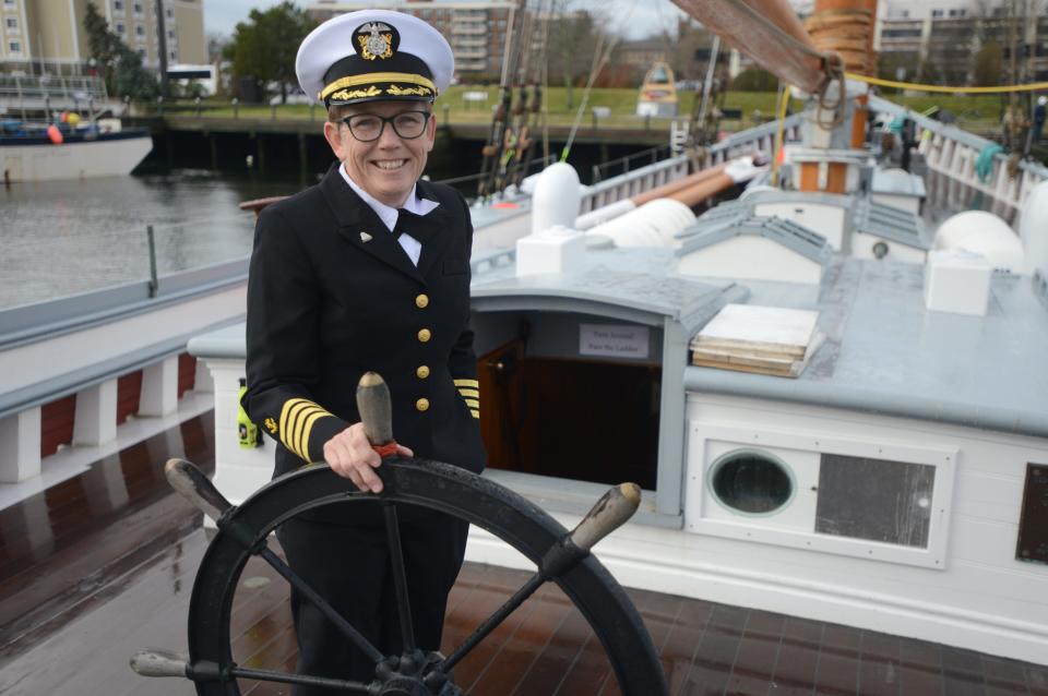 Capt. Tiffany Krihwan stands at the helm of the Ernestina-Morrissey during a homecoming celebration for the tall ship at the State Pier in New Bedford on Saturday.