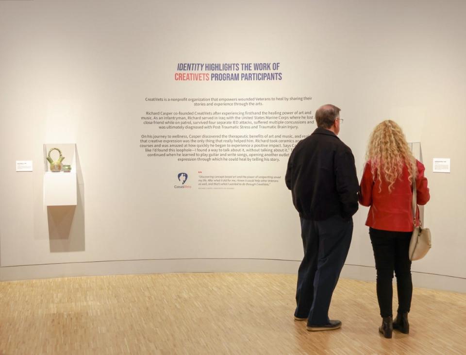 Visitors read about the “IDENTITY" exhibit at the National Veterans Memorial and Museum.