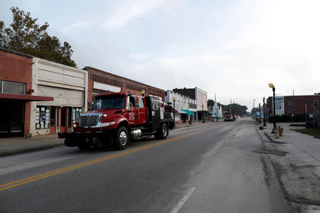 Railroad trucks speed down Main Street after flooding due to Hurricane Florence receded in Fair Bluff, North Carolina, U.S. September 29, 2018. REUTERS/Randall Hill
