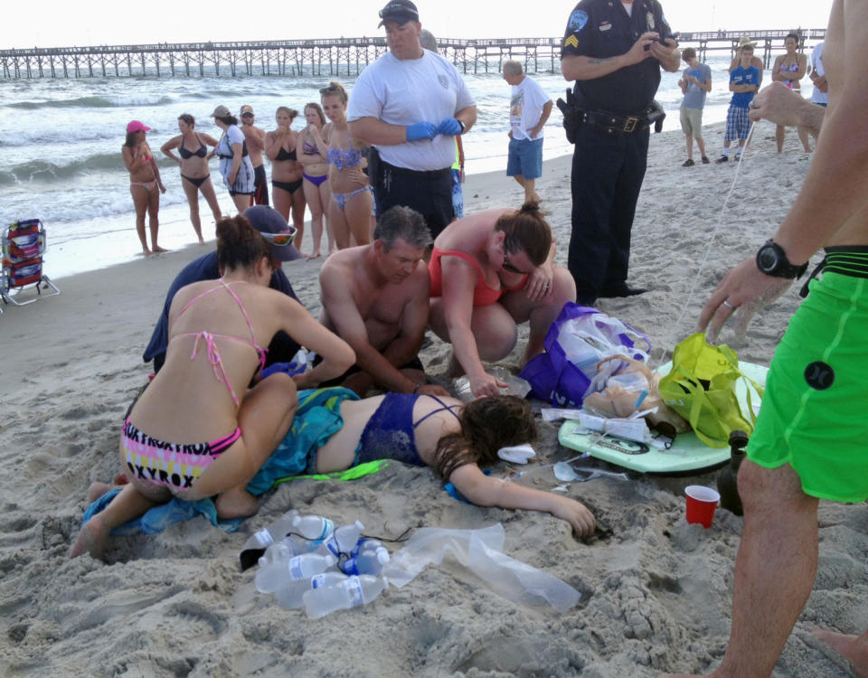 Una joven es atendida tras ser atacada por un tiburón en la playa de Oak Island, Carolina del Norte. (AP)