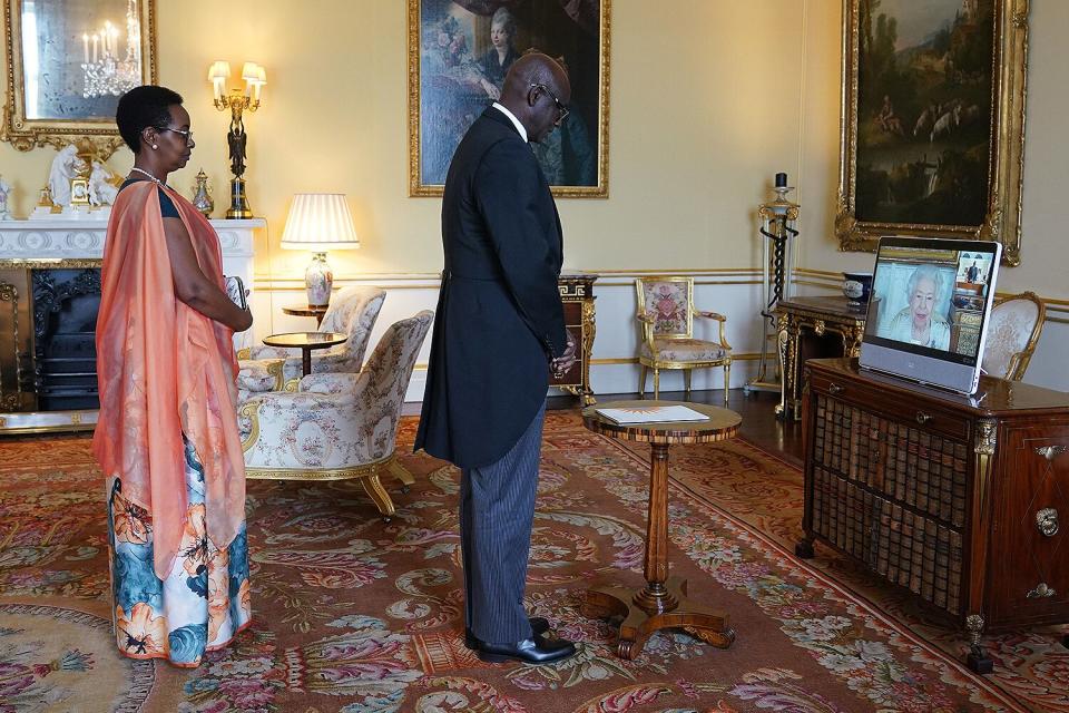 Queen Elizabeth II, in residence at Windsor Castle, appears on a screen via videolink, during a virtual audience to receive Johnston Busingye, High Commissioner for the Republic of Rwanda, and his wife Phoebe Murerwa, at Buckingham Palace on April 29, 2022 in London, England.