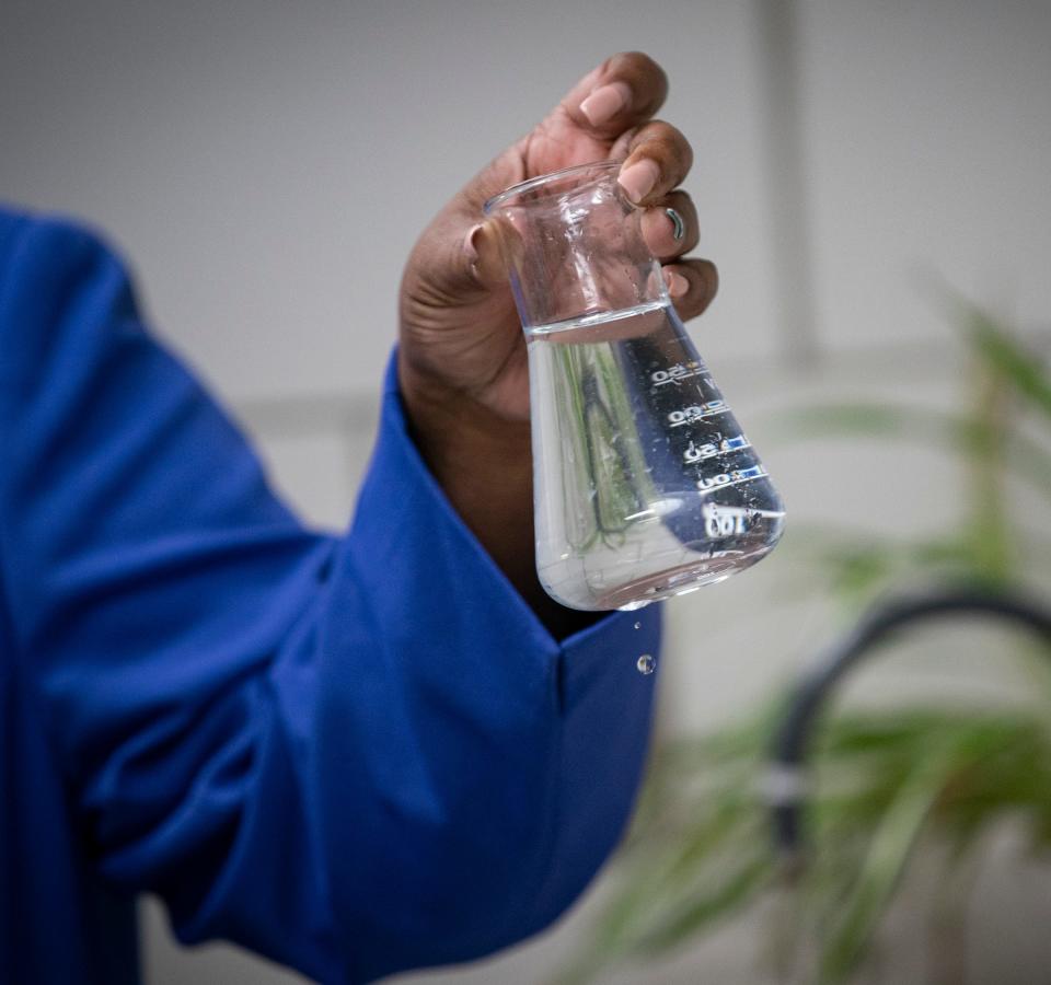 Cheryl Porter, chief operating officer for water and field services of the Great Lakes Water Authority, holds a beaker of raw water from the chemistry lab at the Water Works Park treatment plant in Detroit in April 24, 2023. At the plant, ozone disinfection reduces the taste and odor of chlorine at household taps, Porter said.