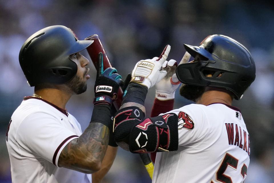 Arizona Diamondbacks' Christian Walker, right, celebrates his home run against the Kansas City Royals with teammate David Peralta, left, during the first inning of a baseball game Monday, May 23, 2022, in Phoenix. (AP Photo/Ross D. Franklin)