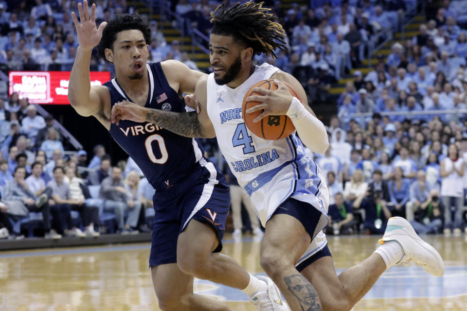 North Carolina guard R.J. Davis (4) drives against Virginia guard Kihei Clark (0) during the first half of an NCAA college basketball game Saturday, Feb. 25, 2023, in Chapel Hill, N.C. (AP Photo/Chris Seward)