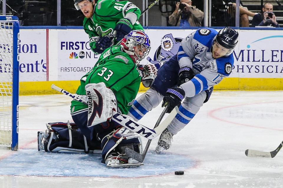 Jacksonville Icemen forward James Sanchez (12) is successfully defended by Florida Everblades goaltender Cam Johnson (33) during an ECHL playoff hockey game at Veterans Memorial Arena in Jacksonville, Fla., Tuesday, May 10, 2022.  [Gary Lloyd McCullough/For the Jacksonville Icemen]