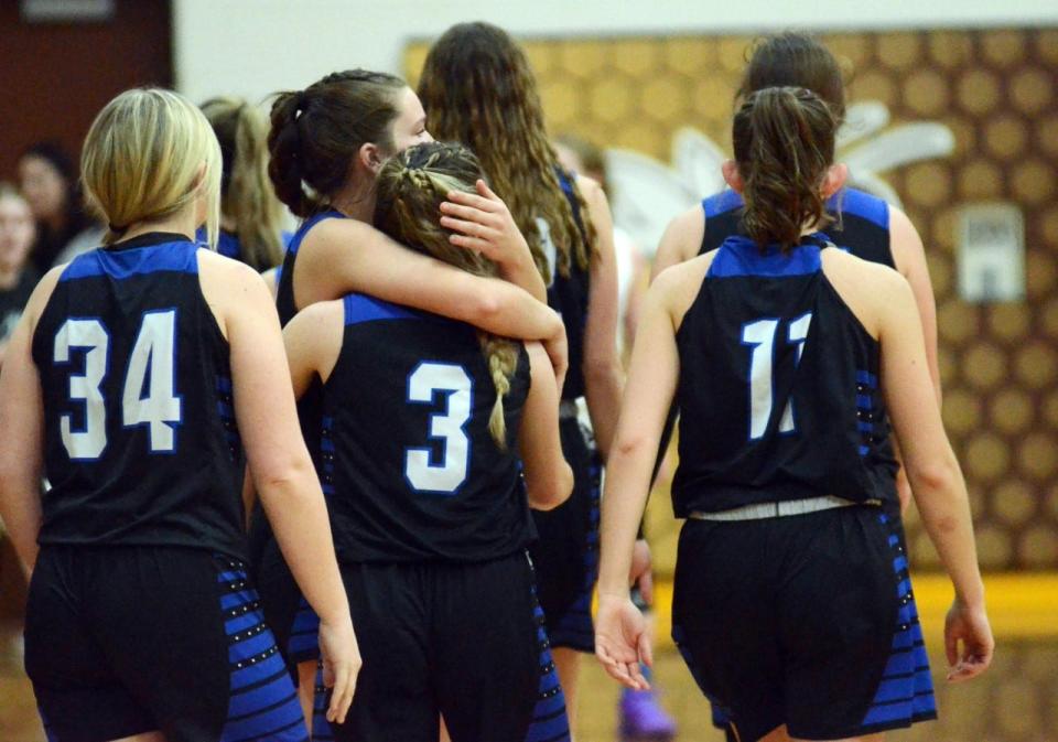 Inland Lakes players embrace and walk off the court after Mackinaw City claimed a Division 4 regional championship over the Bulldogs Thursday night in Pellston.