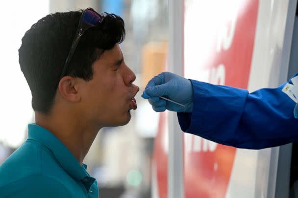 PHOTO: A medical technician administers a COVID-19 test to a man in Time Square in New York City, July 15, 2022. (Anthony Behar/Sipa USA via AP)