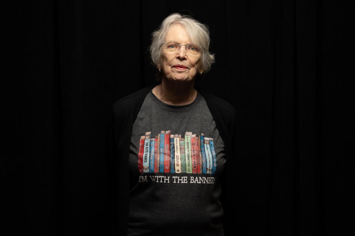 A woman appears against a black background wearing a T-shirt that says, "I'm with the banned."