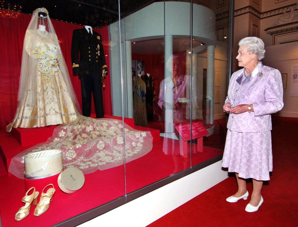 <p>In celebration of her milestone marriage to her husband, a summer exhibition was held at Buckingham Palace that featured the couple's wedding outfits. She wore a gown and a 13-foot bridal trail designed by Norman Hartnel while Prince Philip donned a naval uniform.<br></p>