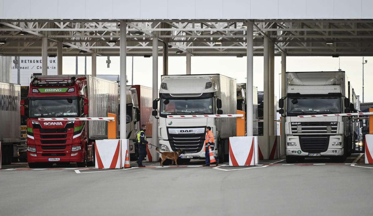 FILE - In this Tuesday, Sept. 17, 2019 file photo, an employee of Eurotunnel and his dog check trucks on their way to Britain during a day of test in case of no deal Brexit, at the exit of the Channel tunnel in Calais, northern France. Britain’s government watchdog says there is still a “significant amount” of work to do to ensure Britain has an adequate medicines supply in case of a no-deal Brexit. In a report issued on Friday, Sept. 27, the National Audit Office said additional shipping capacity chartered by the U.K. for sending goods across the English channel might not be operational until the end of November - one month after the Oct. 31 deadline. (Denis Charlet, Pool via AP, file)