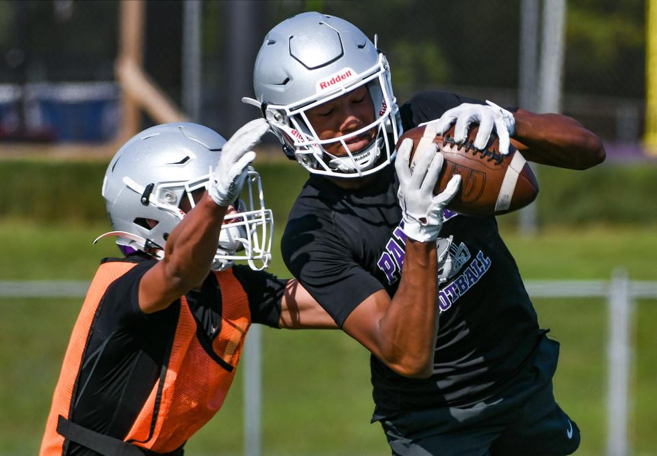 Bloomington South’s D’Andre Black (right) catches a pass during the first day of football practice at South on Monday, July 31, 2023.