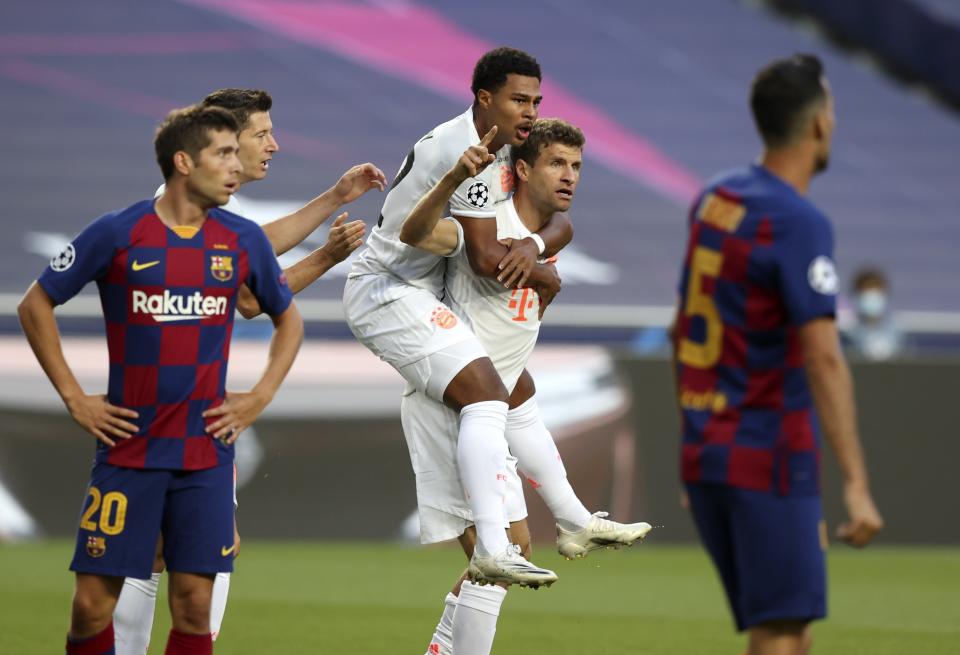 Bayern's Thomas Mueller, bottom center, celebrates after scoring the opening goal during the Champions League quarterfinal soccer match between Barcelona and Bayern Munich in Lisbon, Portugal, Friday, Aug. 14, 2020. (Rafael Marchante/Pool via AP)