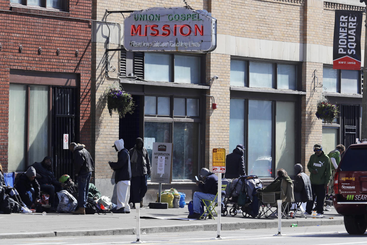 People gather on the sidewalk in front of the Union Gospel Mission in downtown Seattle on Friday. The mission serves a large portion of Seattle's homeless population, and officials fear that controlling the spread of the new coronavirus in groups that lack access to basic hygiene and other supplies will be difficult.&nbsp; (Photo: Ted S. Warren/ASSOCIATED PRESS)