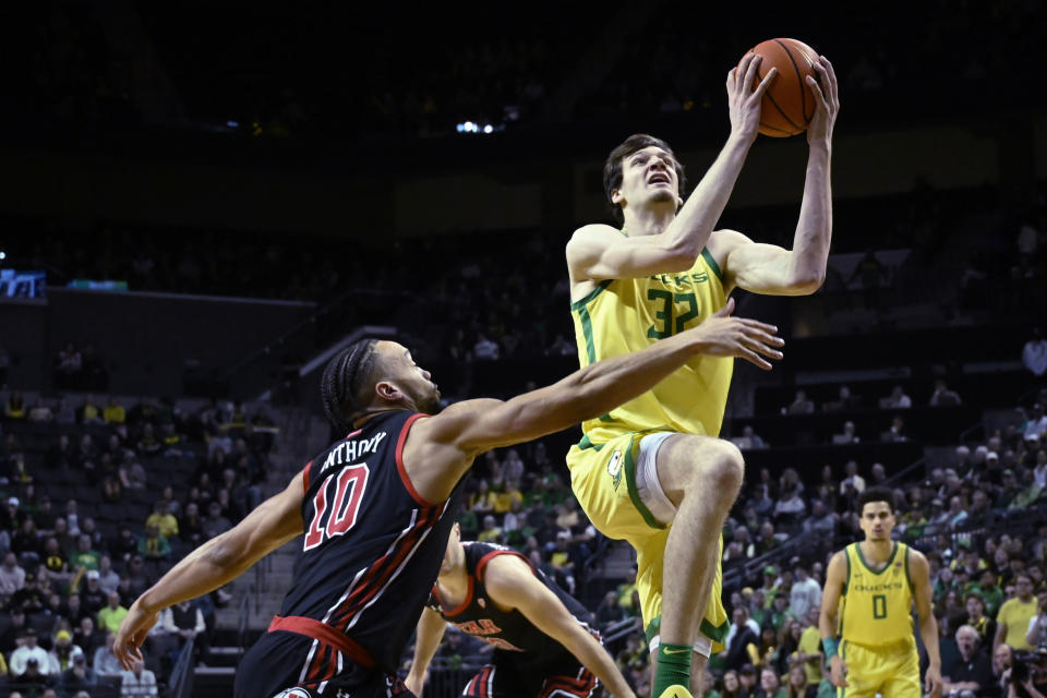 Oregon center Nate Bittle (32) is fouled by Utah guard Marco Anthony (10) as he drives to the basket during the first half of an NCAA college basketball game Saturday, Jan. 28, 2023, in Eugene, Ore. (AP Photo/Andy Nelson)