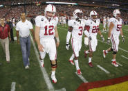 GLENDALE, AZ - JANUARY 02: (L-R) Pro golfer Tiger Woods, Andrew Luck #12, Michael Thomas #3, Delano Howell #26 and David DeCastro #52 of the Stanford Cardinal walks out onto the field for the coinn toss against the Oklahoma State Cowboys during the Tostitos Fiesta Bowl on January 2, 2012 at University of Phoenix Stadium in Glendale, Arizona. (Photo by Pool/Getty Images)