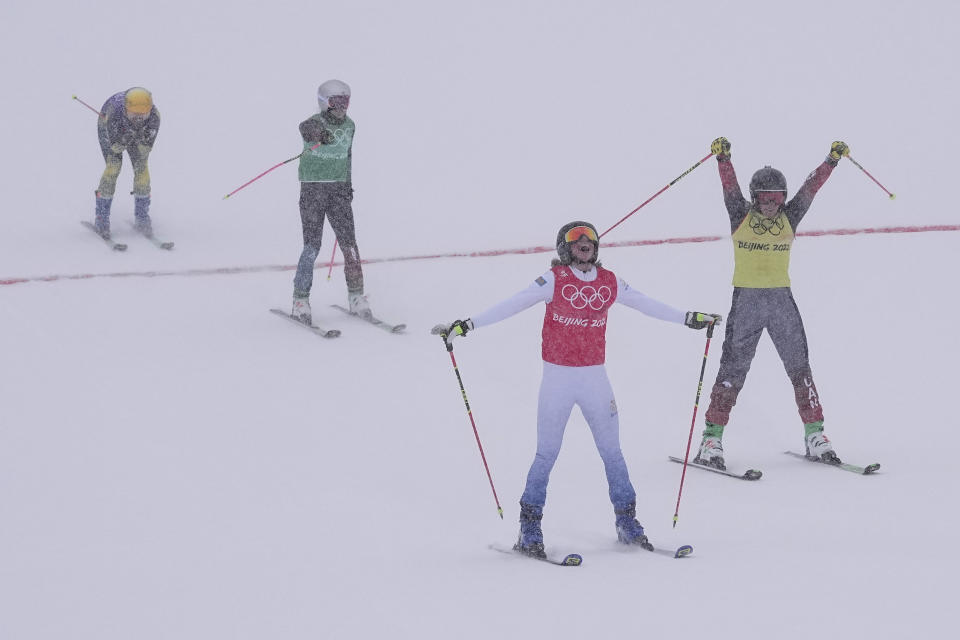 Gold medal winner Sweden's Sandra Naeslund, red, and Silver medal winner Canada's Marielle Thompson, yellow, celebrate after crossing the finish line during the women's cross big final at the 2022 Winter Olympics, Thursday, Feb. 17, 2022, in Zhangjiakou, China. (AP Photo/Gregory Bull)