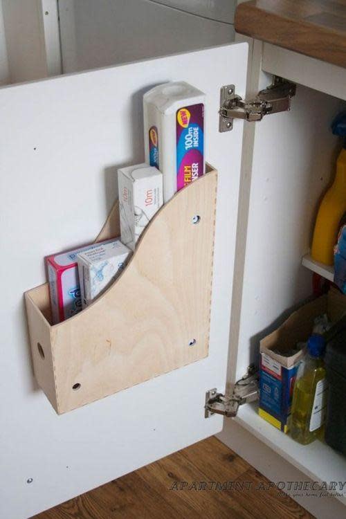 magazine holder repurposed and attached to sink door