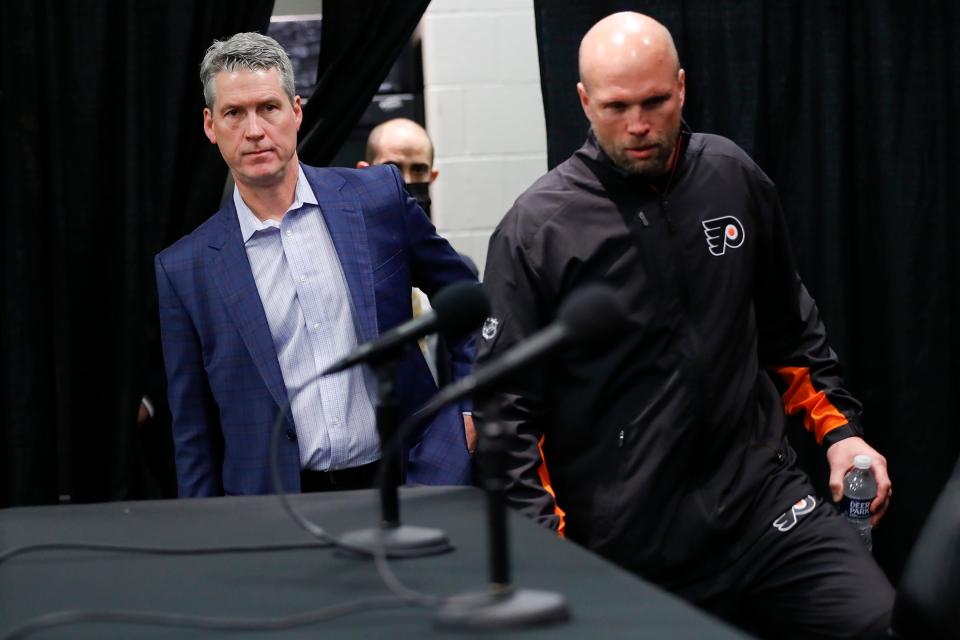 Philadelphia Flyers NHL team President of Hockey Operations and General Manager Chuck Fletcher, left, and Flyers interim head coach Mike Yeo arrive to meet with the media after the Flyers announced they have relieved head coach Alain Vigneault and assistant coach Michel Therrien of their duties, effective immediately, at Wells Fargo Center in Philadelphia, Monday, Dec. 6, 2021. (Yong Kim/The Philadelphia Inquirer via AP)