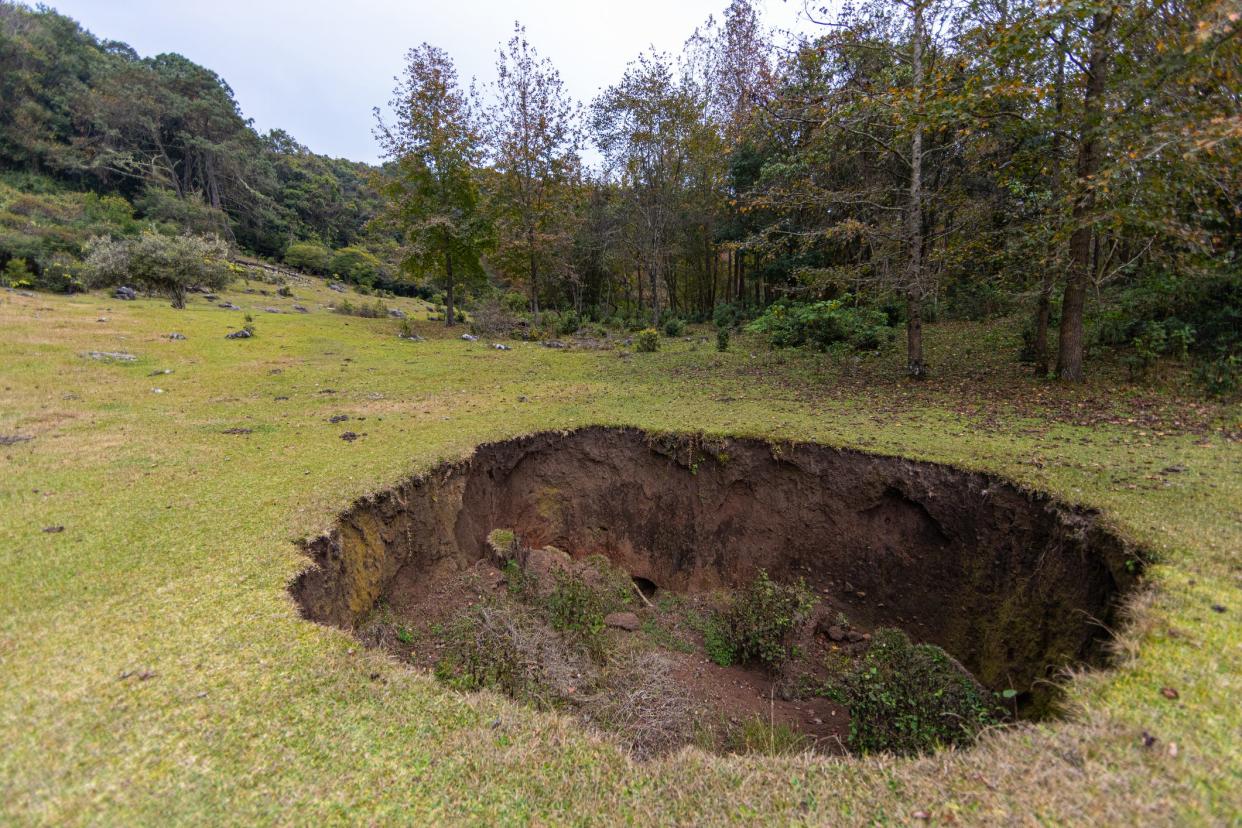 A large sinkhole is pictured in a valley in the middle of the mountains in el Cielo, Tamaulipas, Mexico