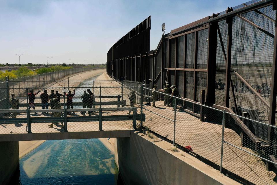 An aerial image shows migrants being searched after waiting on the U.S. side of the border wall to surrender to U.S. Customs and Border Protection Border Patrol agents for immigration and asylum claim processing on the U.S.-Mexico border in El Paso, Texas, on May 10, 2023. The U.S. on May 11, 2023, will officially end its 40-month COVID-19 emergency, also discarding the Title 42 law, a tool that has been used to prevent millions of migrants from entering the country. (Photo by Patrick T. Fallon / AFP)