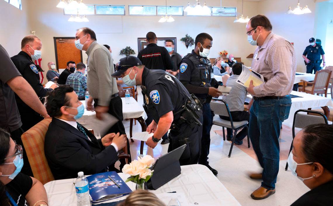 Tacoma police officers talk with business operators concerned for their safey at the Hosmer Business Association meeting on Hosmer Street in Tacoma, Washington on June 22, 2022.