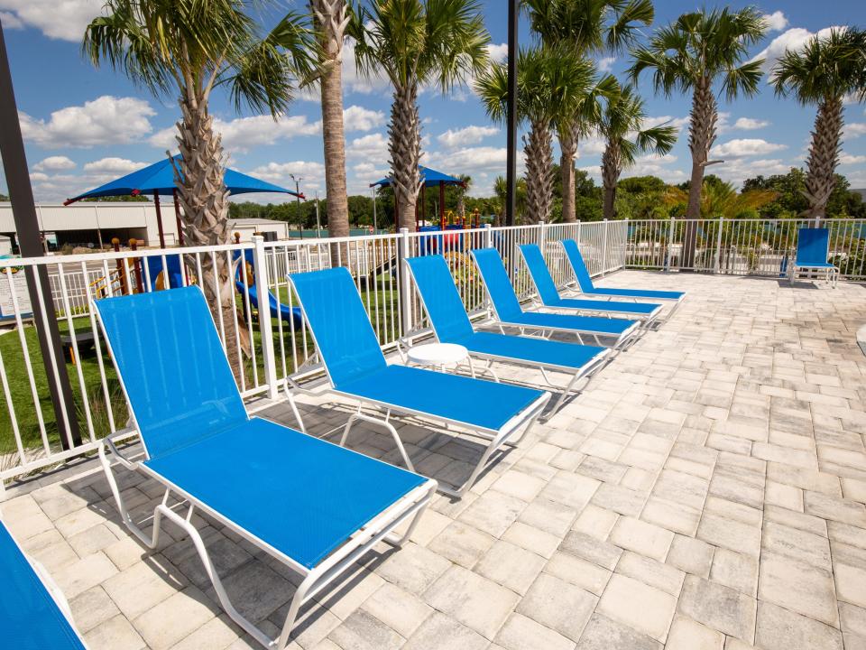 Beach chairs in front of a white gate.