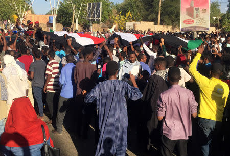 Sudanese demonstrators wave the national flag as they chant slogans during a protest demanding Sudanese President Omar Al-Bashir to step down in Khartoum, Sudan April 6, 2019. REUTERS/Stringer