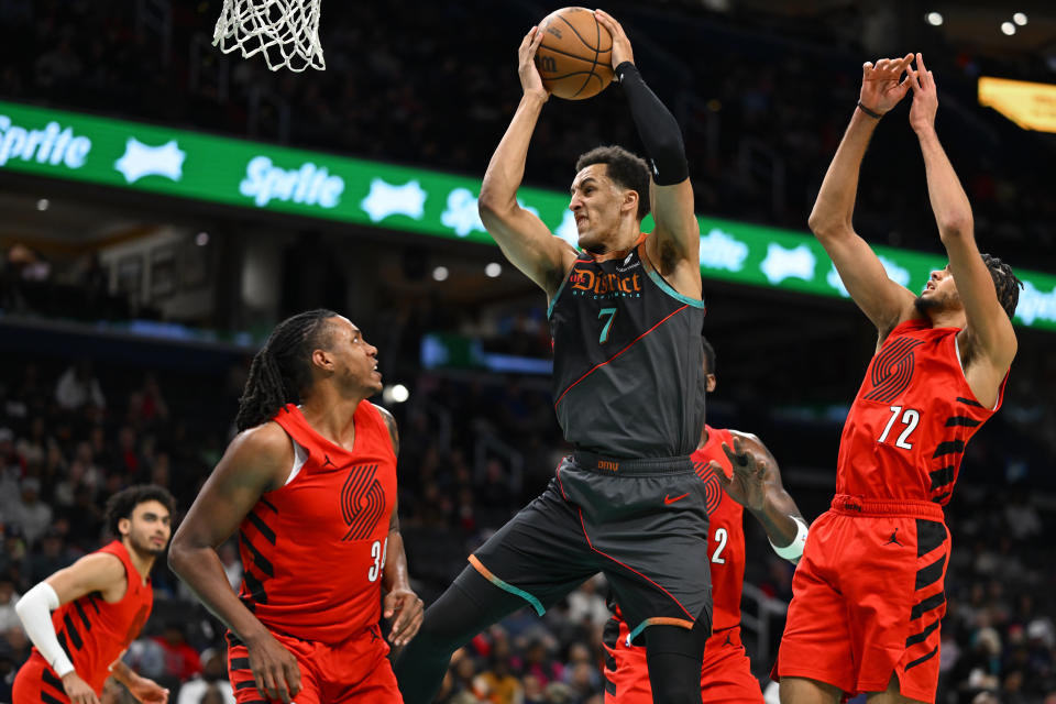 Washington Wizards forward Patrick Baldwin Jr., (7) hauls down a rebound between Portland Trail Blazers forward Jabari Walker, and Trail Blazers guard Rayan Rupert (72) during the first half of an NBA basketball game Friday, April 5, 2024, in Washington. (AP Photo/John McDonnell)