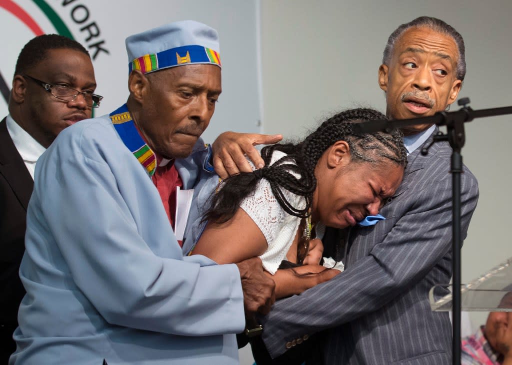 FILE – Esaw Garner, center, wife of Eric Garner, breaks down in the arms of Rev. Herbert Daughtry and Rev. Al Sharpton, right, during a rally at the National Action Network headquarters for Eric Garner, Saturday, July 19, 2014, in New York. Garner, 43, died Thursday, during an arrest in Staten Island, when a plain-clothes police officer placed him in what appeared be a chokehold while several others brought him to the ground and struggled to place him in handcuffs. (AP Photo/John Minchillo, File)