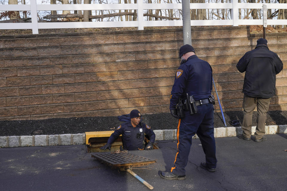 Police search inside a drainage grate near the home of Sayreville councilwoman Eunice Dwumfour in the Parlin area of Sayreville, N.J., Thursday, Feb. 2, 2023. Dwumfour was found shot to death in an SUV parked outside her home on Wednesday. According to the Middlesex County prosecutor's office, she had been shot multiple times and was pronounced dead at the scene. (AP Photo/Seth Wenig)