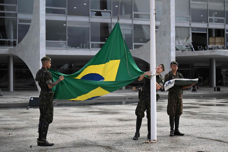 Soldados izan una nueva bandera brasileña en el Palacio Planalto en Brasilia