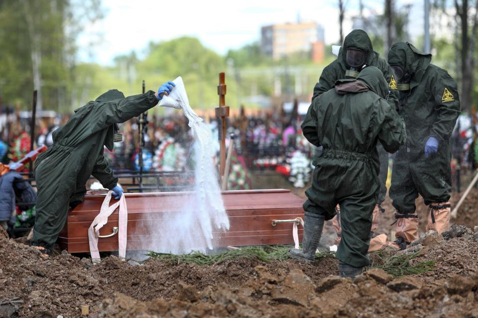 FILE - In this May 15, 2020, file photo, cemetery workers in protective suits disinfect a grave as they bury a COVID-19 victim in a section of the Butovskoye cemetery reserved for coronavirus victims outside Moscow, Russia. Coronavirus deaths in Russia hit a record on Friday, Oct. 1, 2021 for the fourth straight day, and confirmed cases continued to surge as well. Russia's state coronavirus task force reported 887 deaths, the country's highest daily number in the pandemic. The previous record, from a day earlier, stood at 867. (Kirill Zykov, Moscow News Agency photo via AP, File)
