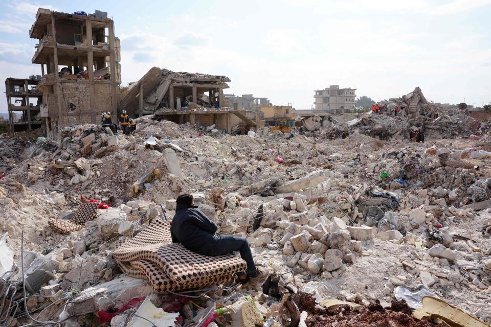 A resident rests on a salvaged mattress, as search and rescue operations continue days after a deadly earthquake hit Turkey and Syria, in the town of Jindayris, in the rebel-held part of Aleppo province in Syria on Feb. 10, 2023. (Photo by Rami al SAYED / AFP)