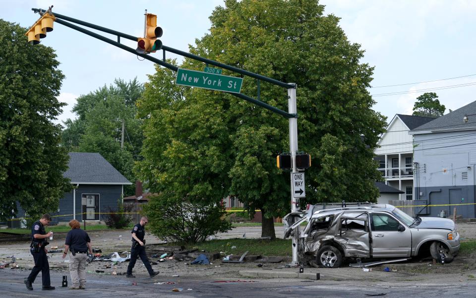 Law enforcement officials work the scene of an accident that officials say left left six kids and two adults injured on Tuesday, July 23, 2024, near the intersection of North State Avenue and East New York Street in Indianapolis.