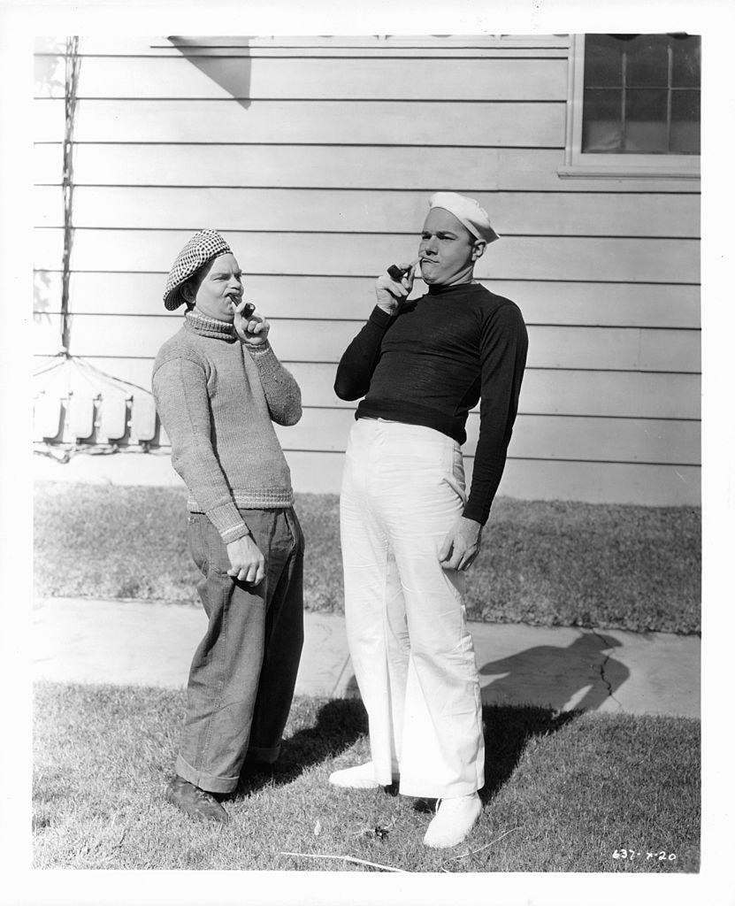 Haines smoking with a costar while wearing a sailor's outfit