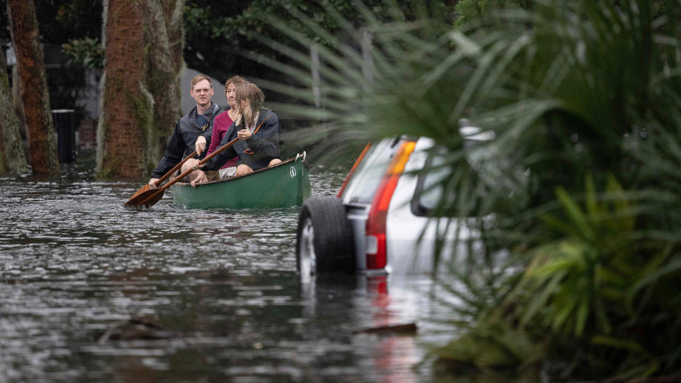 People paddle by in a canoe next to a submerged car in the aftermath of Hurricane Ian in Orlando, Florida on Sept. 29, 2022. / Credit: JIM WATSON/AFP via Getty Images