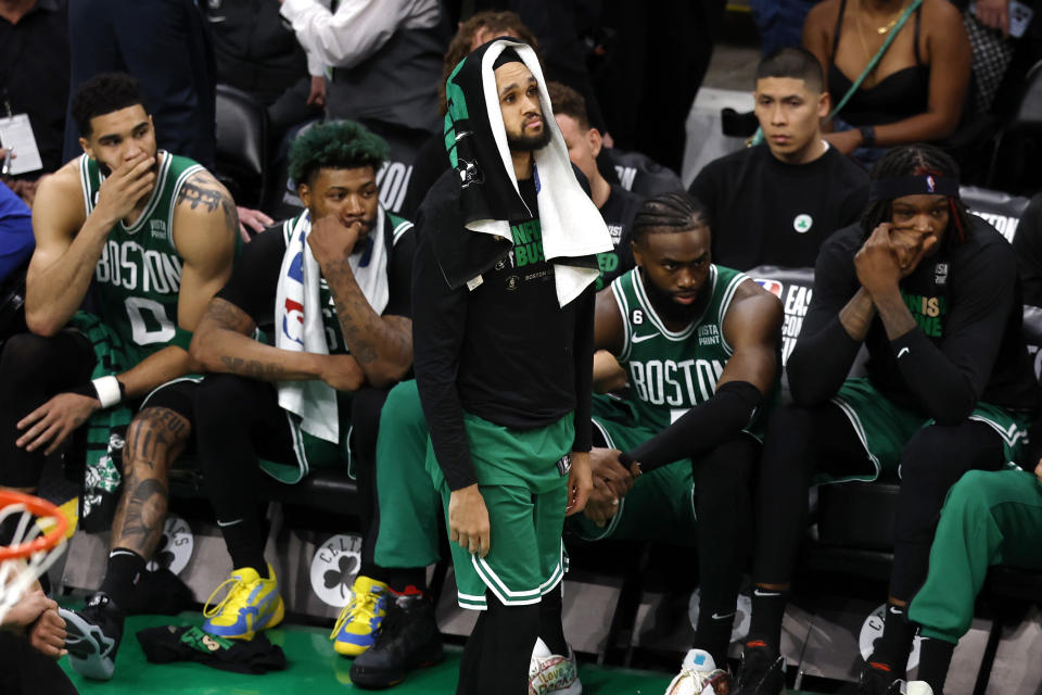 Boston Celtics guard Derrick White, center, stands in front of the bench as his teammates sit behind him in the closing seconds of the second half in Game 7 of the NBA basketball Eastern Conference finals against the Miami Heat Monday, May 29, 2023, in Boston. (AP Photo/Michael Dwyer)