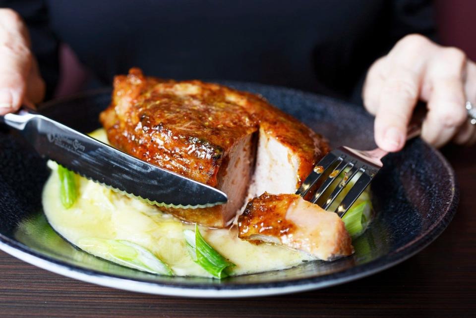 At Lewis Prime Grill, a double-cut grilled pork chop is served in a mustard glaze over creamed leeks.