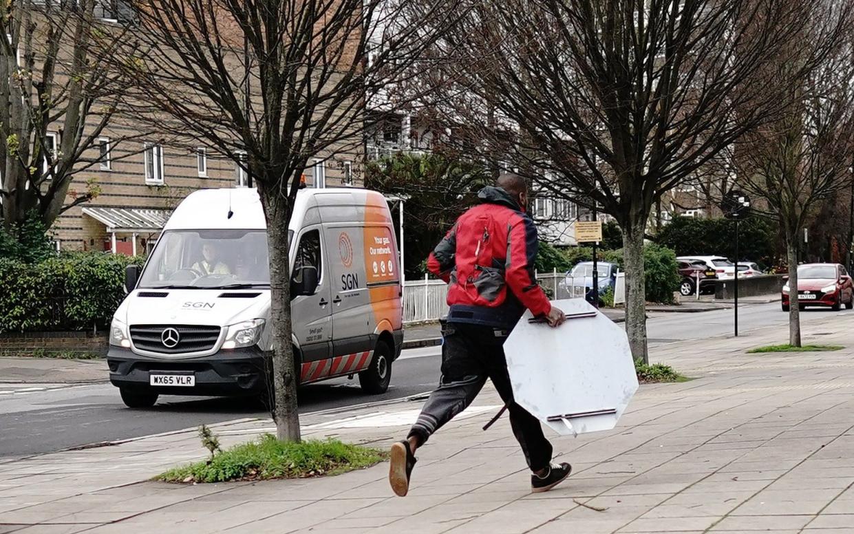 A man runs off with an object from the junction in Peckham where the Banksy artwork had been installed