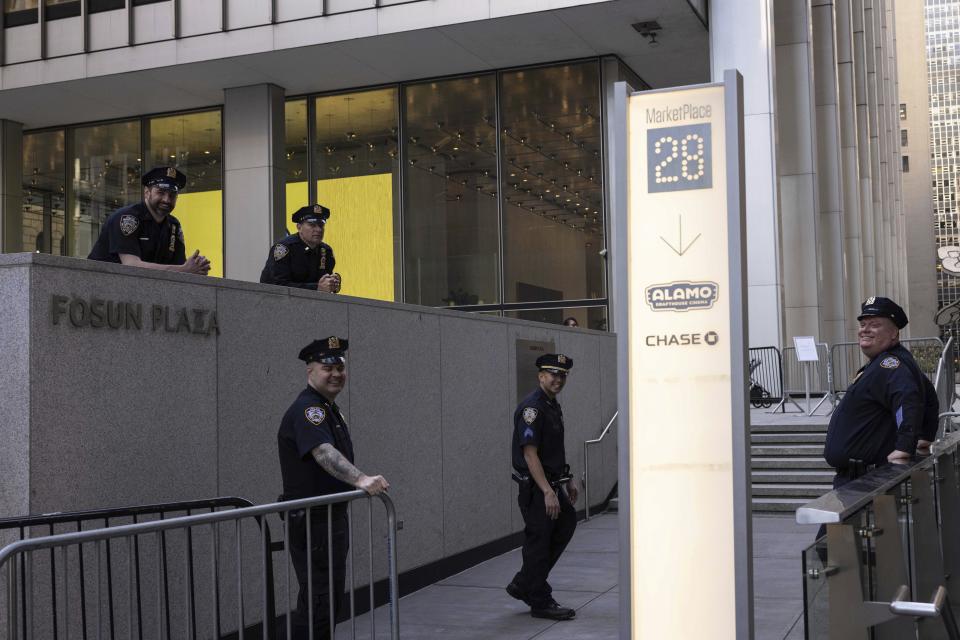 Police officers stand outside an Attorney General's office building for depositions in a civil investigation in New York, Thursday, April. 13, 2023. Trump is scheduled to meet with lawyers for Attorney General Letitia James, who sued Trump last year. Her lawsuit claims Trump and his family misled banks and business associates by giving them false information about his net worth and the value of assets such as hotels and golf courses. (AP Photo/Yuki Iwamura)