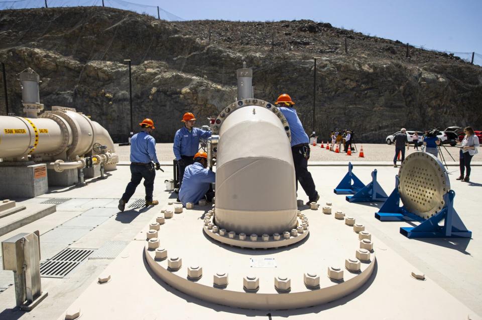 Workers at a giant intake pipe