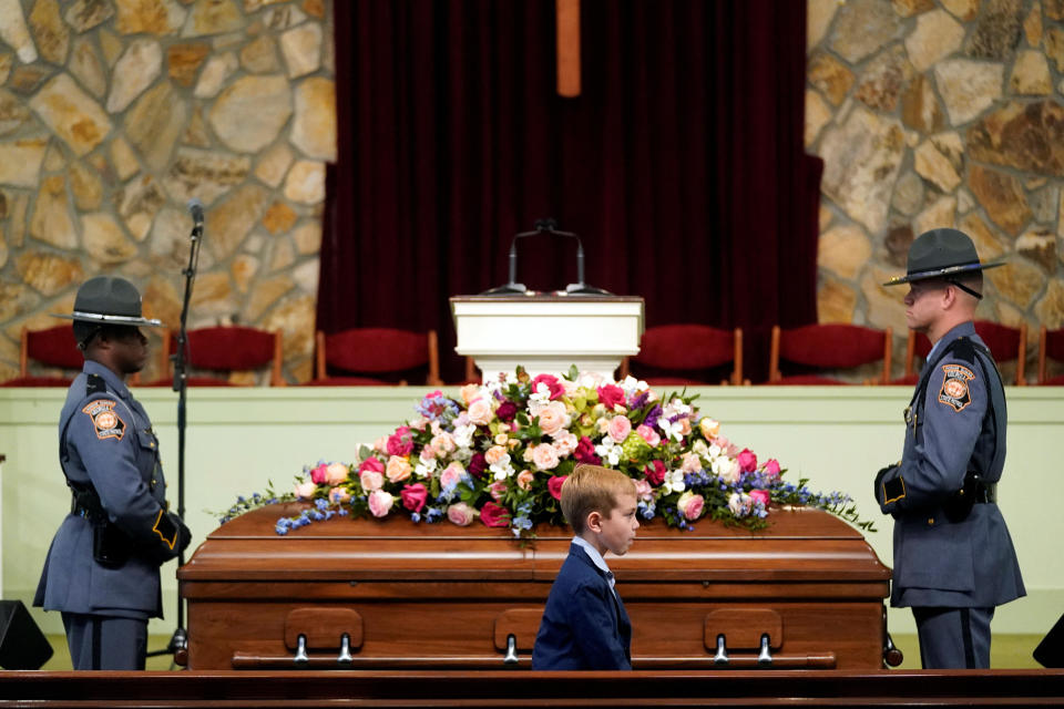 A young mourner walks past the casket before the funeral service for former first lady Rosalynn Carter at Maranatha Baptist Church, in Plains, Georgia,  on Nov. 29.  / Credit: Alex Brandon/Pool via REUTERS