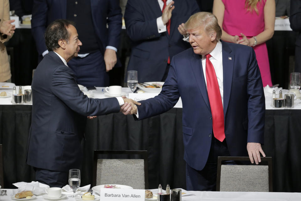 FILE - President Donald Trump, right, shakes hands with John Paulson during a meeting of the Economic Club of New York in New York, Nov. 12, 2019. Trump's campaign is expecting to raise more than $40 million on Saturday, April 6, 2024, when a group of major donors gather at Paulson's Palm Beach, Fla. home for Trump's biggest fundraiser yet as his third White House campaign drastically ramps up fundraising. (AP Photo/Seth Wenig, File)