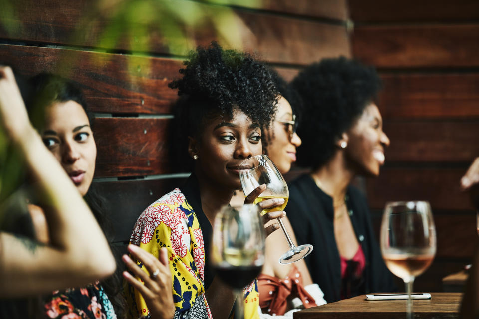 Woman enjoying drink with friends at poolside bar